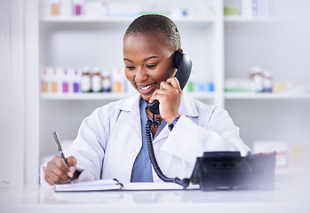Image showing Black woman, phone call and pharmacist writing in notebook for Telehealth consultation at the pharmacy. Happy African female person, medical or healthcare professional talking on telephone at clinic