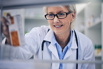 Image showing Senior woman, pharmacist and reading medication on shelf for inventory, diagnosis or prescription at pharmacy. Happy mature female person, medical or healthcare professional checking medicine in shop