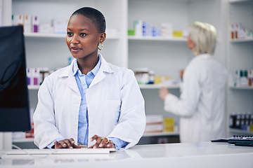 Image showing Pharmacist, typing and black woman on computer in pharmacy, drugstore or shop. Wellness, medical professional and African doctor on internet for telehealth email, healthcare and research for medicine