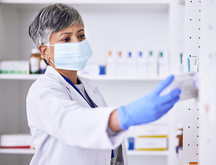 Image showing Pharmacy, medicine and woman in face mask for healthcare, medical inventory and pharmaceutical service. Shelf, product and reading label of pharmacist or senior person for virus, bacteria or covid 19