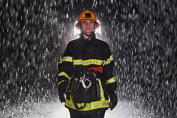 Image showing A determined female firefighter in a professional uniform striding through the dangerous, rainy night on a daring rescue mission, showcasing her unwavering bravery and commitment to saving lives.