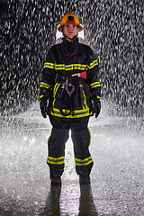 Image showing A determined female firefighter in a professional uniform striding through the dangerous, rainy night on a daring rescue mission, showcasing her unwavering bravery and commitment to saving lives.