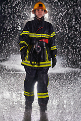 Image showing A determined female firefighter in a professional uniform striding through the dangerous, rainy night on a daring rescue mission, showcasing her unwavering bravery and commitment to saving lives.