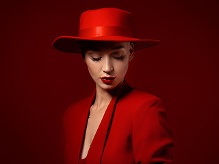 Image showing Beauty, fashion and a model woman on red background in studio for elegant or trendy style. Aesthetic, art and confident with an edgy or classy young female person eyes closed in a unique clothes suit