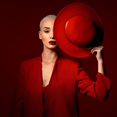 Image showing Portrait, fashion and a model woman on a red studio background for elegant or trendy style. Aesthetic, art and beauty with a young female person looking edgy or classy in a suit or unique clothes