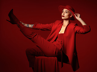 Image showing Vision, fashion and a woman on a chair in studio on a red background for elegant or trendy style. Thinking, art and beauty with a young female person sitting in an edgy, classy or unique suit