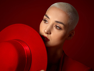 Image showing Face, fashion and a model woman on a red studio background for elegant or trendy style. Future vision, art or beauty with a young female person thinking and looking edgy or classy in a unique outfit