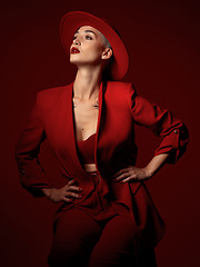 Image showing Confident, fashion and a model woman on a red studio background for elegant or trendy style. Aesthetic, art and beauty with a young female person standing hands on hips in an edgy or classy suit