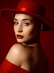 Image showing Portrait, fashion and looking back with a woman on a red studio background for elegant or trendy style. Face, art and beauty with a young female model posing closeup in an edgy or classy outfit