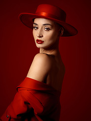 Image showing Portrait, fashion and a woman runway model on a red studio background for elegant or trendy style. Aesthetic, art and beauty with a young female person looking over her shoulder in a classy outfit