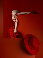 Image showing Portrait, fashion and mock up with a woman on a red background in studio for marketing, advertising or branding. Luxury, aesthetic beauty or style with a trendy young model standing with empty space