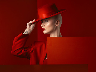 Image showing Fashion, woman and red hat with cosmetic or luxury in studio red background with creative retro suit. Style, runway and girl with makeup with vintage clothes with confident, unique and edgy model.
