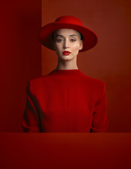 Image showing Portrait, reverse fashion and mockup with a woman on a red background in studio for marketing, advertising or branding. Luxury, aesthetic style or trendy young female model standing with empty space