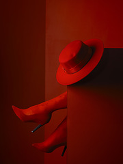 Image showing Red heels, hat and feet in studio, sexy and aesthetic for retro couture design, luxury clothes or mystery by background. Stiletto shoes, fedora and relax with high fashion, elegance and vintage style