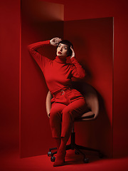 Image showing Fashion, beauty and a young woman on red background in studio for elegant, chic or trendy style. Aesthetic, art and confident with an edgy or classy model person in unique clothes or suit at board