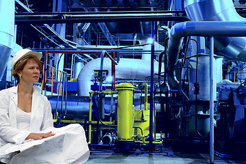 Image showing woman engineer, equipment, cables and piping as found inside of 