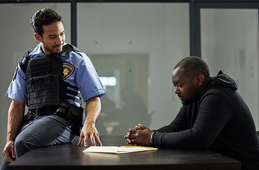 Image showing Police, interrogation and black man, suspect or criminal investigation for crime at station. African person with handcuffs at table, detective and people in discussion, interview and law questions.