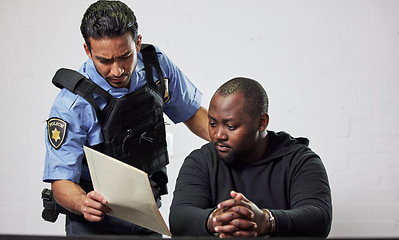 Image showing Policeman, criminal and handcuffs with documents for interrogation, question or arrest in fraud, scam or crime. Law enforcement officer talking to prisoner or thief with paperwork in prison or jail