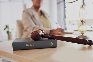 Image showing Gavel, law firm and books on table of attorney in office for judge, justice and court trial. Closeup of advocate, lawyer and worker with hammer, research and legal notebook at desk for constitution