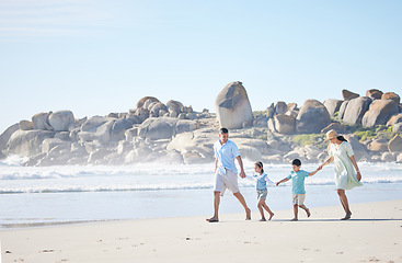 Image showing Beach, walking and family holding hands while on a vacation, holiday or adventure. Freedom, love and children with their parents bonding together by the ocean or sea on a tropical summer weekend trip