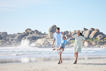 Image showing Family, parents and swinging a child at the beach for fun, adventure and play on holiday. A happy woman, man and young kid walking on sand and holding hands on vacation at ocean, nature or outdoor