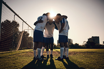 Image showing Soccer, sunset or team in a huddle for motivation, goals or group mission on stadium field for a sports game. Match, sunshine or football players planning a strategy, exercise or training for fitness