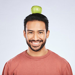 Image showing Portrait, apple head balance and man smile for weight loss diet, healthy snack or body nutrition vitamins. Eating food, nutritionist fruit and studio face of hungry Asian person on white background