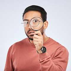 Image showing Magnifying glass, man and focus in a studio with investigation for clues on crime. Isolated, white background and male person with inspection for scam, evidence and information on a job with shock