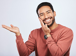Image showing Hand pointing, smile and portrait of asian man in studio with mockup, promotion or news on a white background. Happy, face and male person with platform for menu, open palm or sale announcement