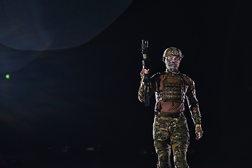 Image showing A professional soldier in full military gear striding through the dark night as he embarks on a perilous military mission