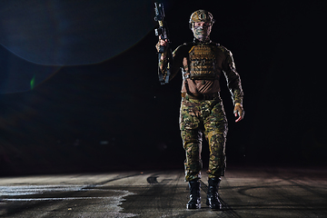 Image showing A professional soldier in full military gear striding through the dark night as he embarks on a perilous military mission