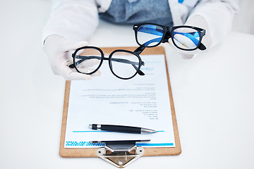 Image showing Hands, vision and glasses test with consulting and healthcare contract in consultation with support. Hospital, lens care and paperwork with doctor and ophthalmologist holding eyewear in clinic