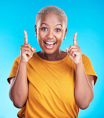 Image showing Excited portrait, pointing up and happy black woman gesture at eureka, problem solving solution or ideas. Wow, OMG notification and African person smile for studio realisation on blue background