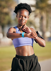 Image showing Fitness, pulse and female athlete on a workout with smartwatch for running outdoor in nature. Sports, exercise and African woman monitoring her heart rate for cardio training for race or marathon.