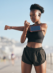 Image showing Thinking, music and stretching with a sports black woman outdoor on a blurred background for cardio or endurance training. Fitness, exercise and phone with a young athlete getting ready for a workout