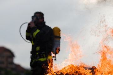 Image showing Portrait of a heroic fireman in a protective suit. Firefighter in fire fighting operation.