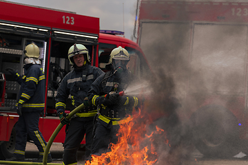 Image showing Firefighters fight the fire flame to control fire not to spreading out. Firefighter industrial and public safety concept. Traffic or car accident rescue and help action.