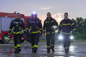 Image showing Brave Firefighters Team Walking to the Camera. In Background Paramedics and Firemen Rescue Team Fight Fire in Car Accident, Insurance and Save Peoples Lives concept.