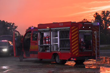 Image showing Fire truck emergency vehicle. Firefighting apparatus and water to save lives, suppress wildfire, extinguish building fires and assist vehicle collisions or traffic car crash accidents.