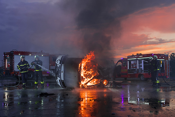 Image showing Firefighters fight the fire flame to control fire not to spreading out. Firefighter industrial and public safety concept. Traffic or car accident rescue and help action.