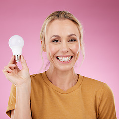 Image showing Lightbulb, portrait and woman isolated on pink background for beauty ideas, inspiration or cosmetics solution. Happy model or mature person with light bulb thinking of dermatology, skincare or health