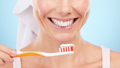 Image showing Closeup of woman, smile and toothbrush isolated on a blue background for dental or orthodontics health. Beauty model or person mouth, brushing teeth with toothbrush product and toothpaste in studio