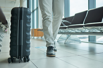 Image showing Travel, suitcase and person legs walking to flight, international opportunity and global journey in lobby. Luggage, entrepreneur or business man at airport for vacation, travel agency or hospitality