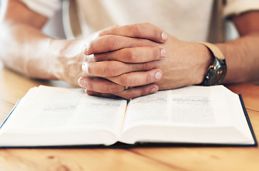 Image showing Religion, reading and hands of a man with a bible for prayer, worship and hope. God, christian and spiritual person with belief in Jesus, looking for support and help from a religious book on a table