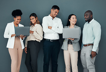 Image showing Business people, group and laptop by wall background in office, corporate startup and coaching with happiness. Young executive team, diversity and mentor with men, women and computer for learning