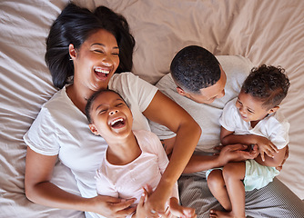 Image showing Top view, love and black family in bedroom, playful and cheerful on weekend break, quality time or happiness. African American mother, father or children on bed, joyful or relax with support or laugh