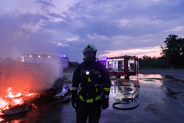 Image showing Portrait of a heroic fireman in a protective suit. Firefighter in fire fighting operation.