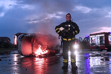 Image showing Portrait of a heroic fireman in a protective suit. Firefighter in fire fighting operation.