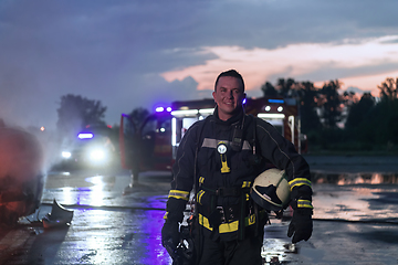 Image showing Portrait of a heroic fireman in a protective suit. Firefighter in fire fighting operation.