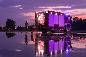 Image showing Fire truck emergency vehicle. Firefighting apparatus and water to save lives, suppress wildfire, extinguish building fires and assist vehicle collisions or traffic car crash accidents.